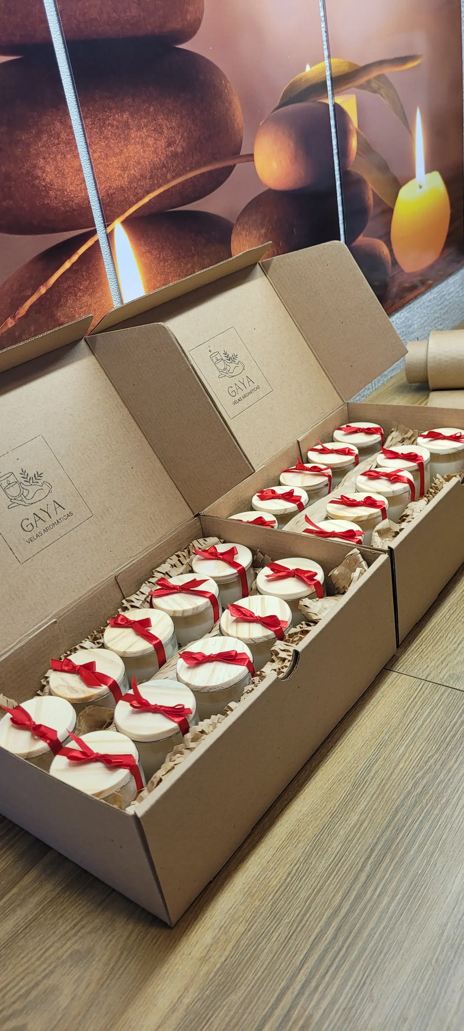 Caixas kraft abertas com mini velas e laços vermelhos