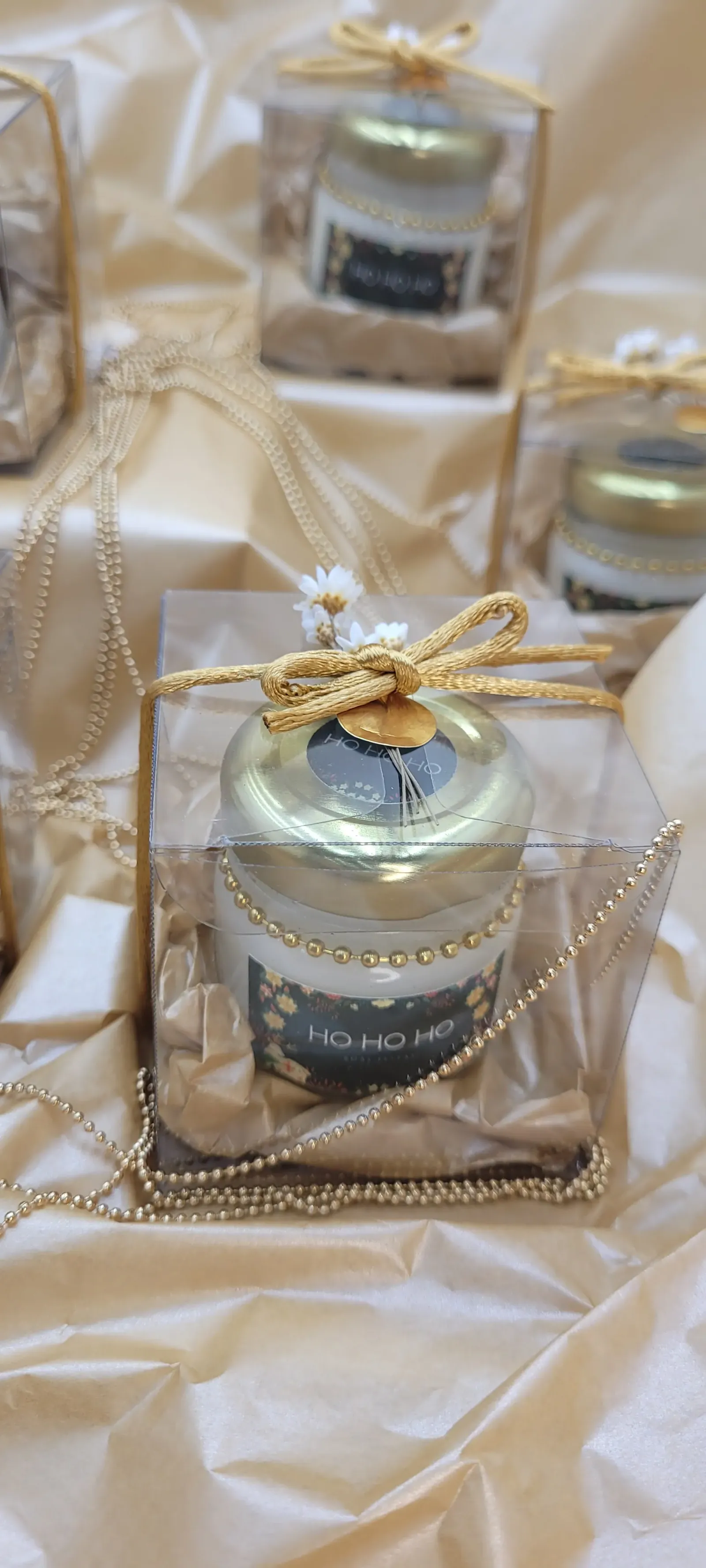 Vela em pote de vidro numa caixa com laço dourado, para o Natal