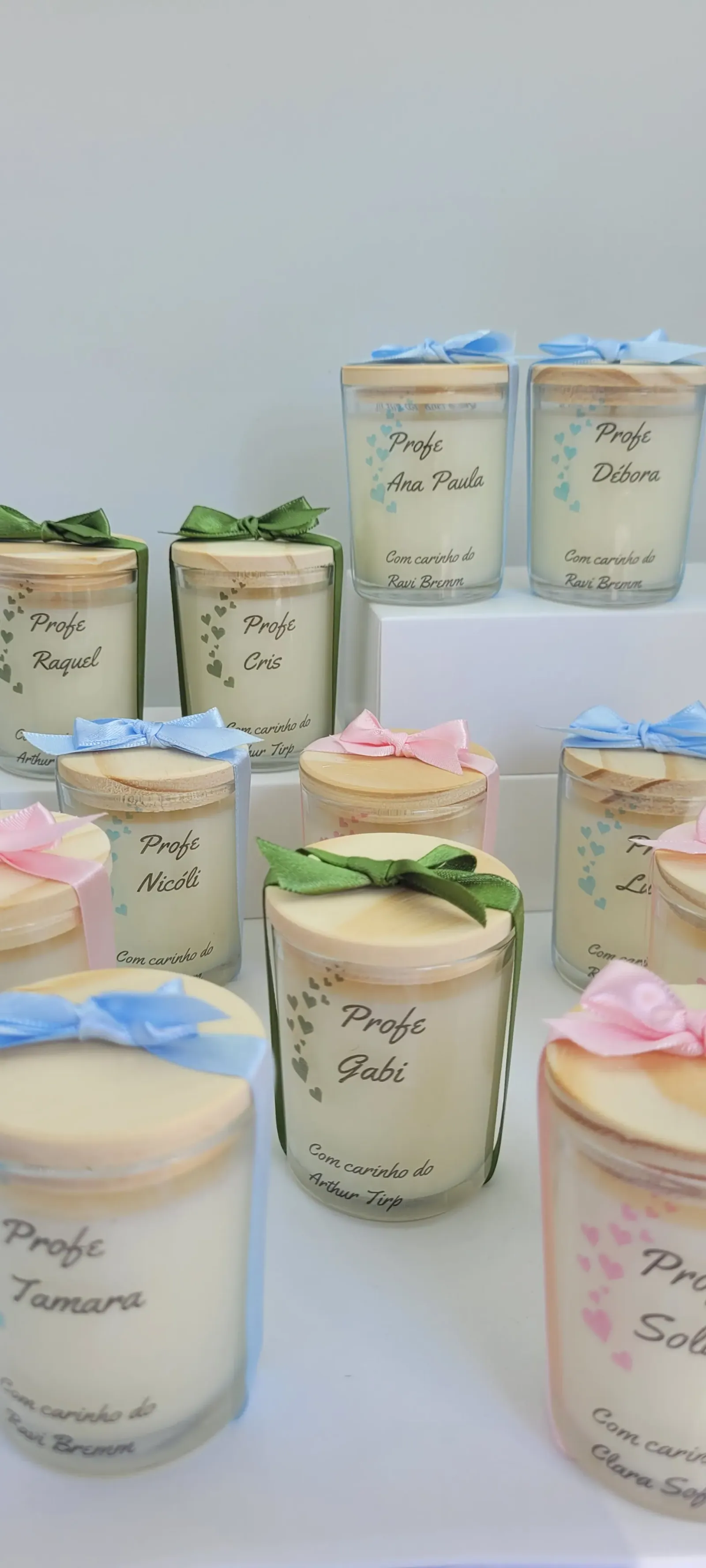 Velas em copos de vidro com tampa de madeira, laços e rótulos personalizados com nomes