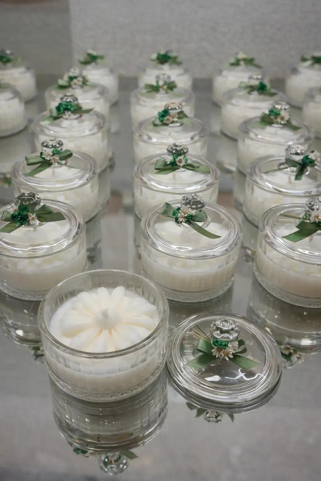 Velas em potes de vidro com tampa de vidro, flor e laço verde