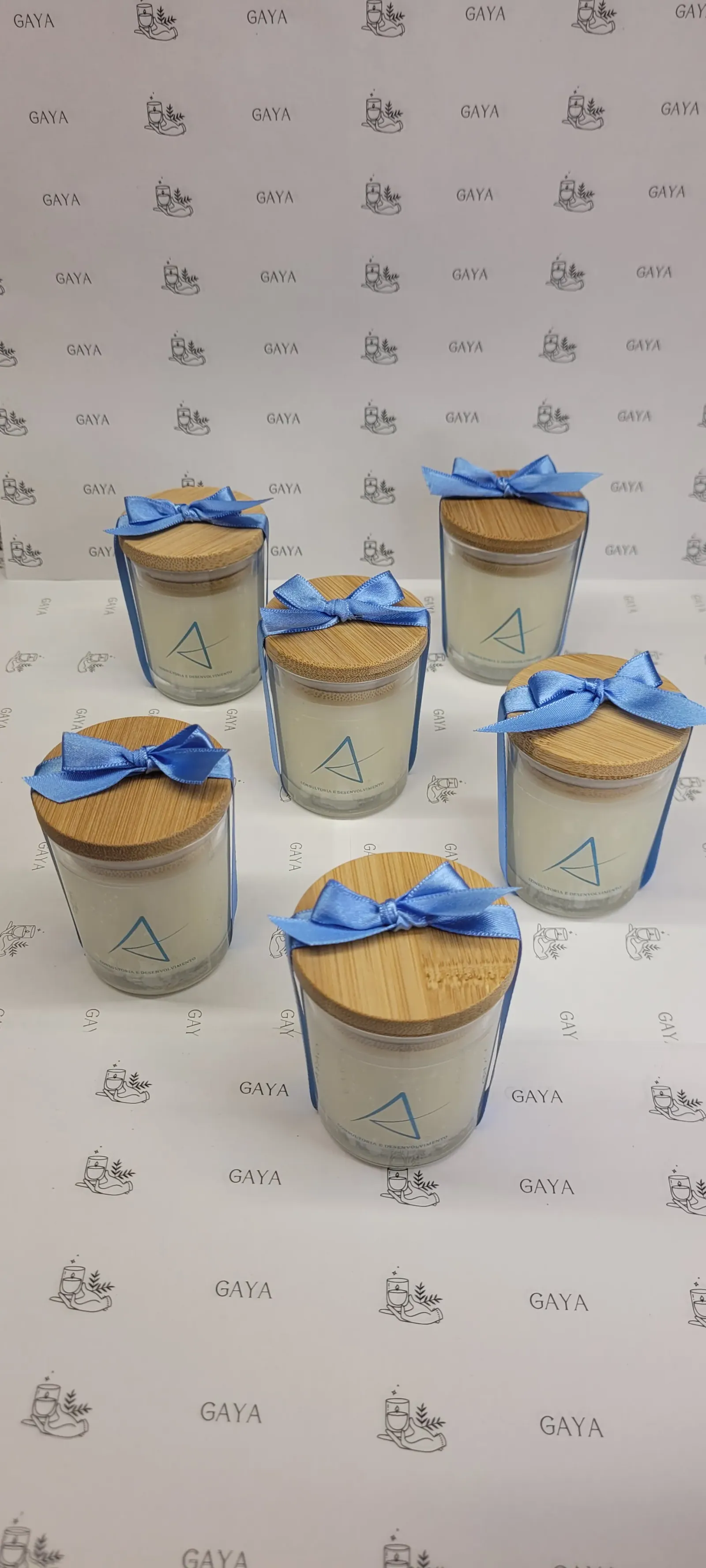 Velas em copo de vidro com tampa de madeira e laço azul